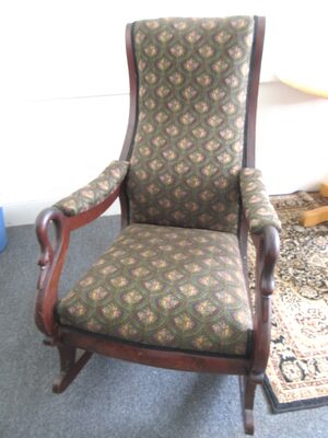 %%Antique Rocking Chair%%, Donated by Yellow Magnolia Antiques, an antique shop that was open in Hancock, NH from 2015-2024; Sturdy, wooden chair in good shape (some scratches in stain); Beautiful fabric in excellent condition; No other information available; Larger photo shows close-up of fabric print.