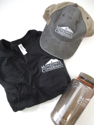 %%Monadnock Conservancy%%, Keene, NH; Monadnock Conservancy Swag Bag; Includes: Adult Size L black t-shirt (50% cotton/50% polyester), Pacific Headwear Vintage Collection cap (size 37), Nalgene 32 oz. water bottle. As a land trust for southwestern NH, our mission is to work with communities and landowners to conserve the natural resources, wild and working lands, rural character, and scenic beauty of the Monadnock region. We care for our conservation lands, and we engage people in ways that strengthen their communities and their connections to the land. https://www.monadnockconservancy.org/