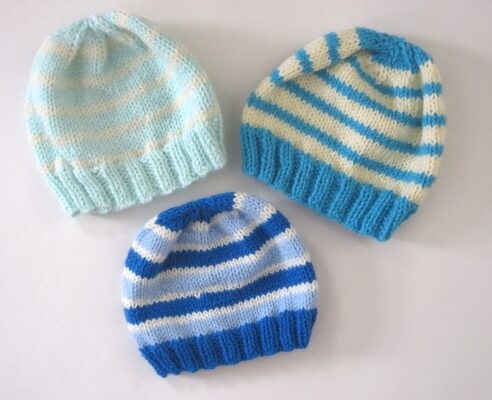 %%Three Handknit Infant Hats%%, Made and donated by Anne Morris, Peterborough, NH; Acrylic yarn; Stripes in various shades of blue.