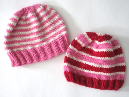 %%Two Handknit Infant/Toddler Hats%%, Made and donated by Anne Morris, Peterborough, NH; Acrylic yarn; One hat is pink and off-white and the other hat is pink, red, and off-white.