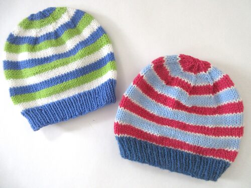 %%Two Handknit Toddler Hats%%, Made and donated by Anne Morris, Peterborough, NH; Acrylic yarn; One hat is blue, green, and white and the other hat is dark pink, white, and 2 shades of blue.