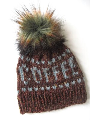 %%Handknit Coffee Hat%%, Made and donated by Alyssa Nykanen; Size: Adult; Yarn: 80% acrylic, 20% wool and alpaca; Color: Brown shades with blue writing; Removeable pop-pom.